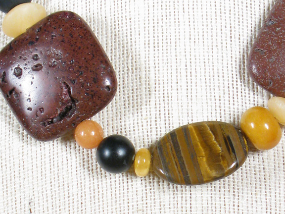 
BROWN LAVA, TIGER, SERPENTINE, AVENTURINE, BLACK ONYX, GOLD JADE & CARNELIAN WITH A GOLD PLATED CLASP