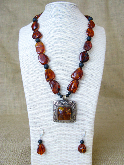 
RUST COLORED AMBER WITH ANTIQUE TIBETIAN AMBER SILVER PENDENT AND STERLING CLASP