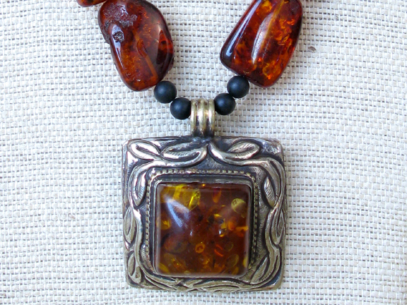 
RUST COLORED AMBER and BLACK ONYX BALLS WITH ANTIQUE TIBETIAN AMBER SILVER PENDENT AND STERLING CLASP
